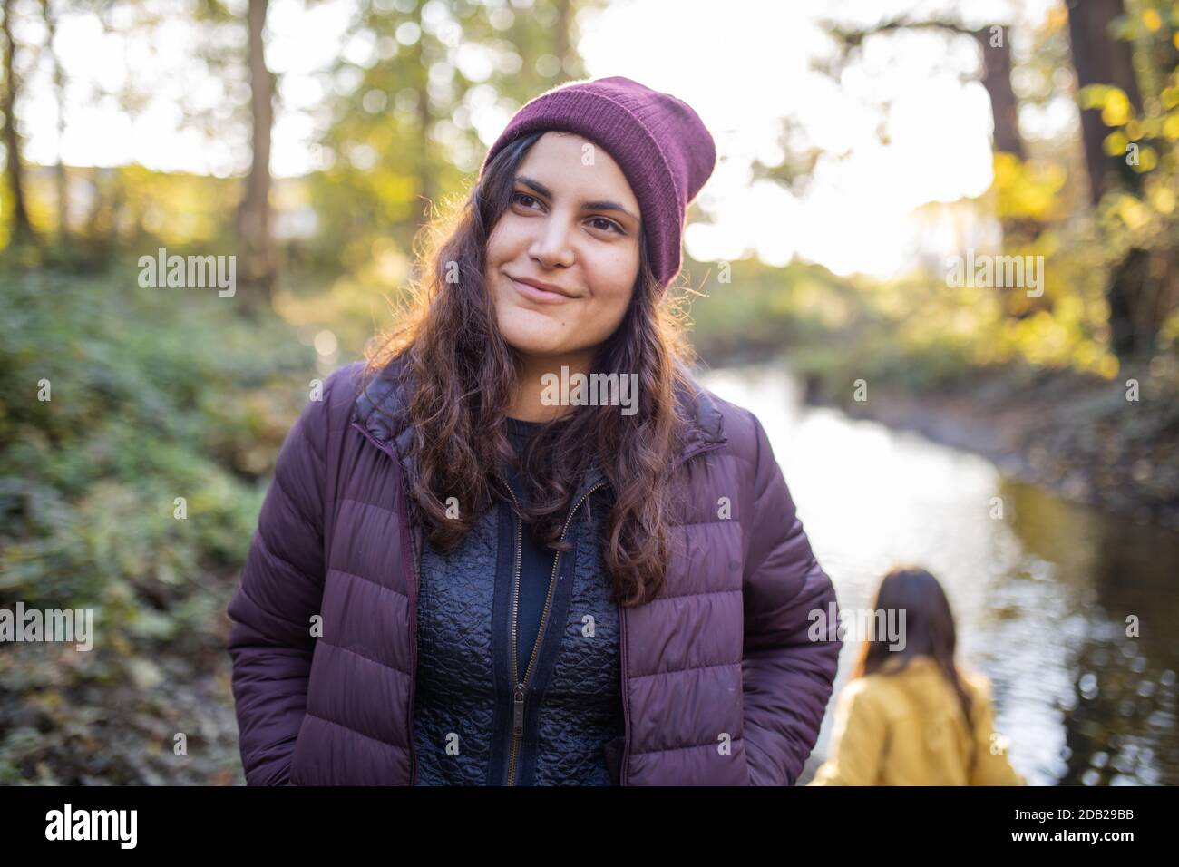 Happy woman standing next to a river in the forest Stock Photo - Alamy