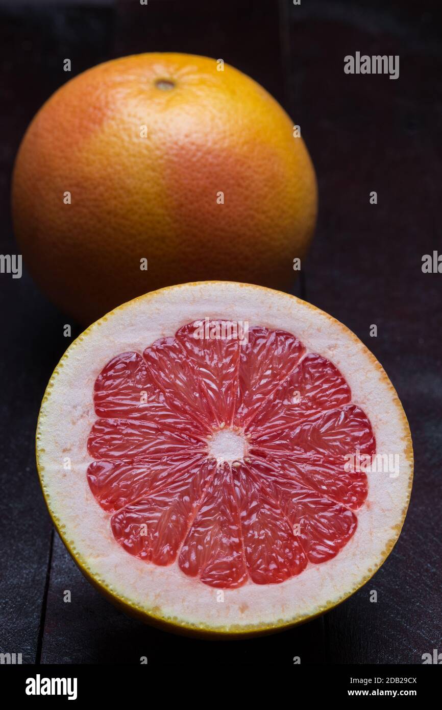 Grapefruit sliced on mahogany wood background. Stock Photo