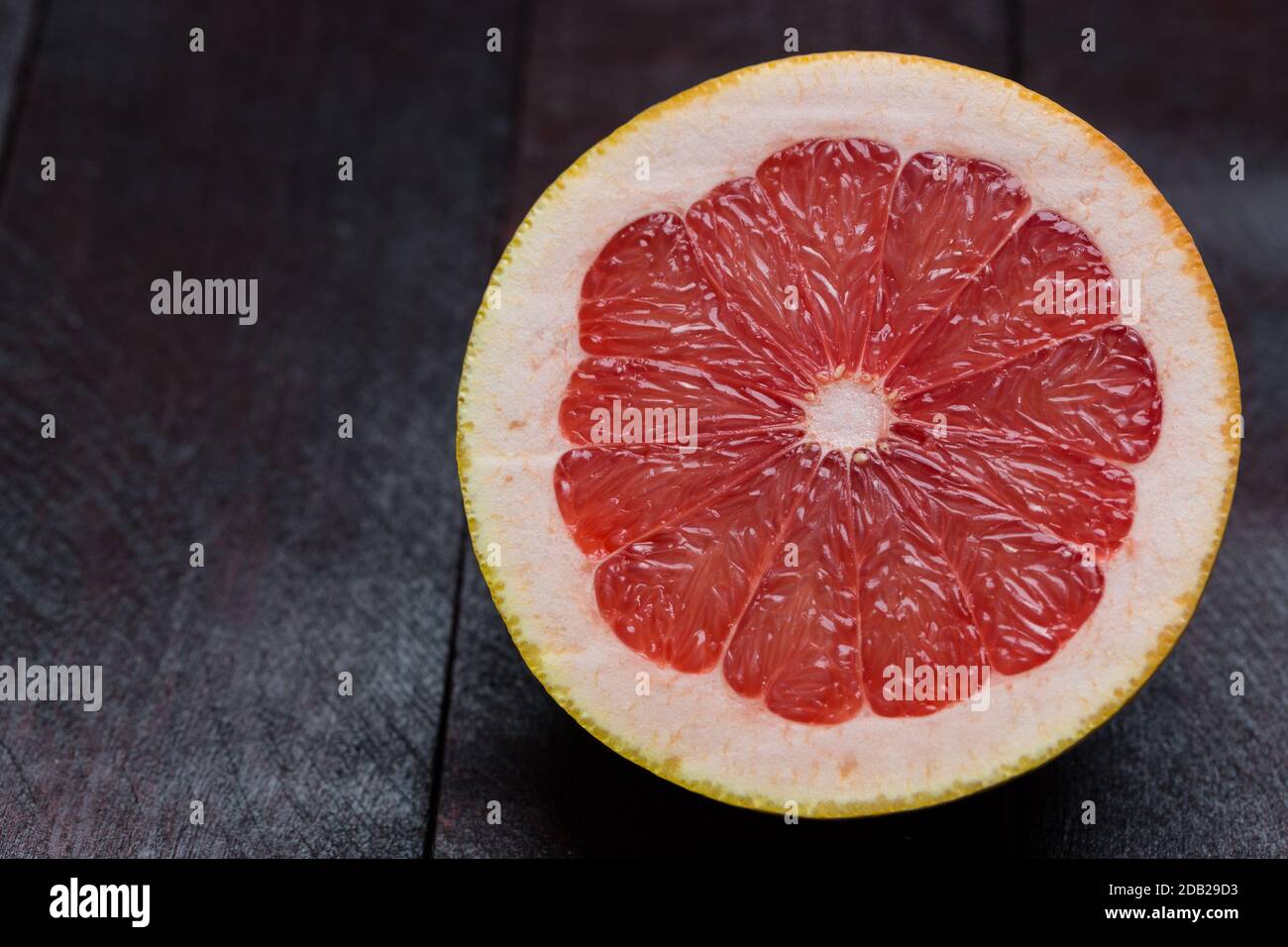 Grapefruit sliced on mahogany wood background. Stock Photo