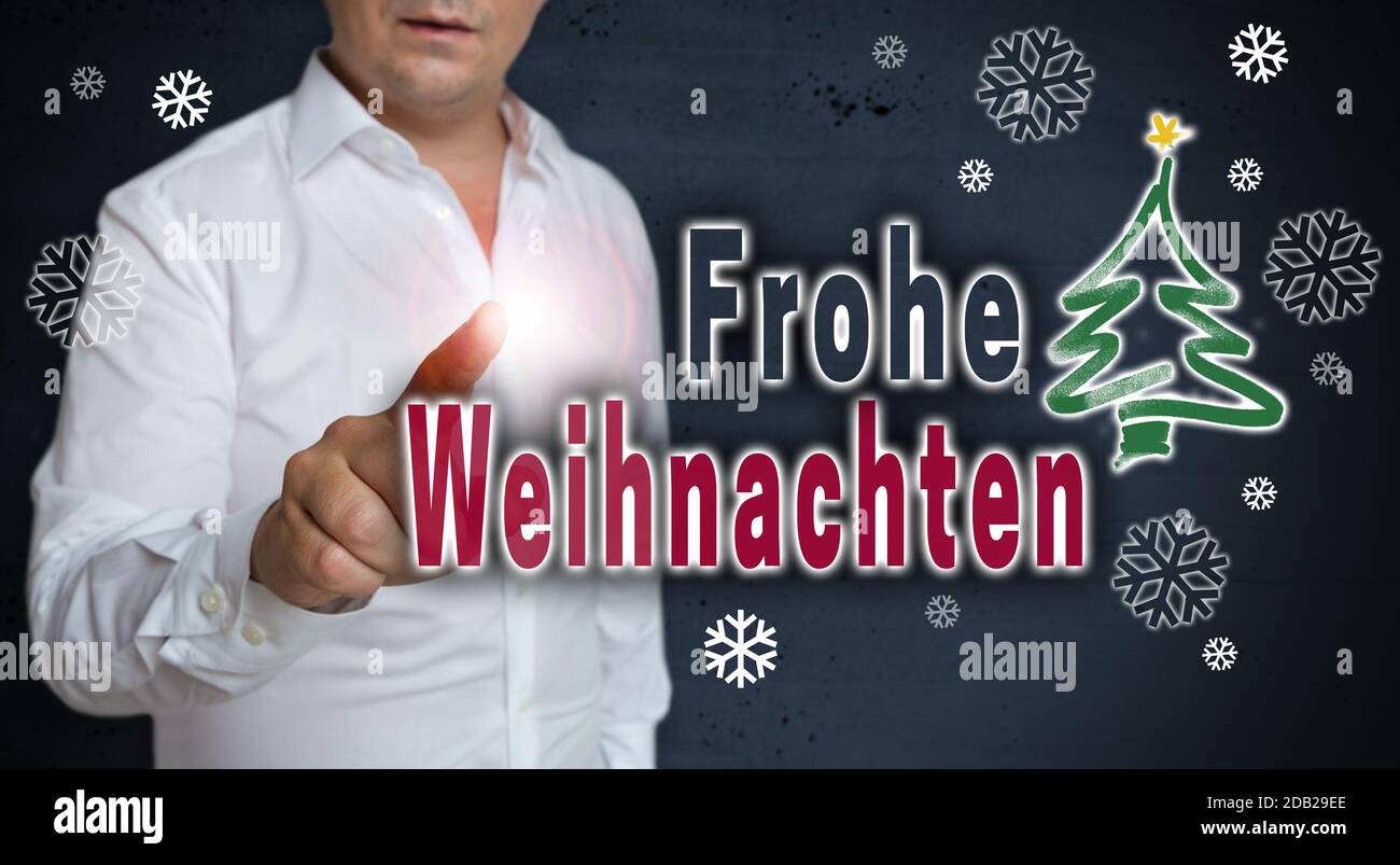 Frohe Weihnachten (in german Merry Christmas) concept touchscreen is operated by man Stock Photo