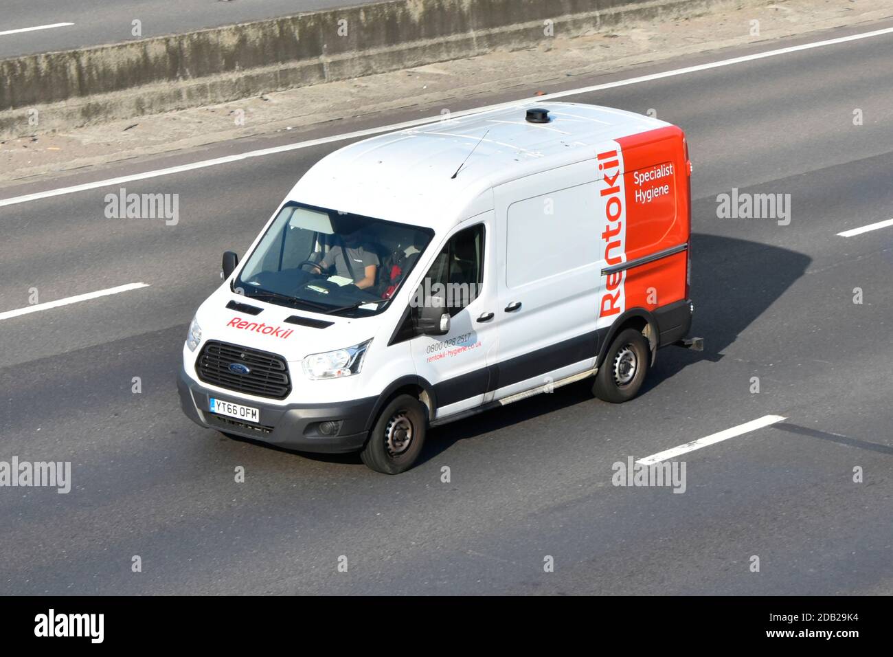 Aerial looking down from above at front & side view of Rentokil Specialist Hygiene business services van & driver travelling on motorway England UK Stock Photo
