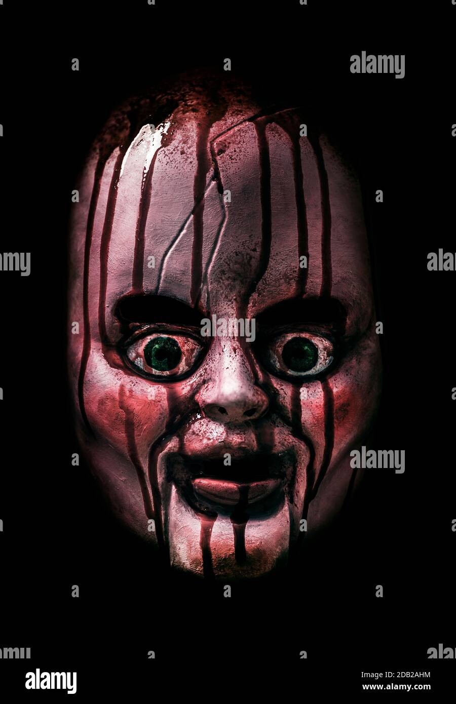 Creepy bloody doll head in the dark Stock Photo