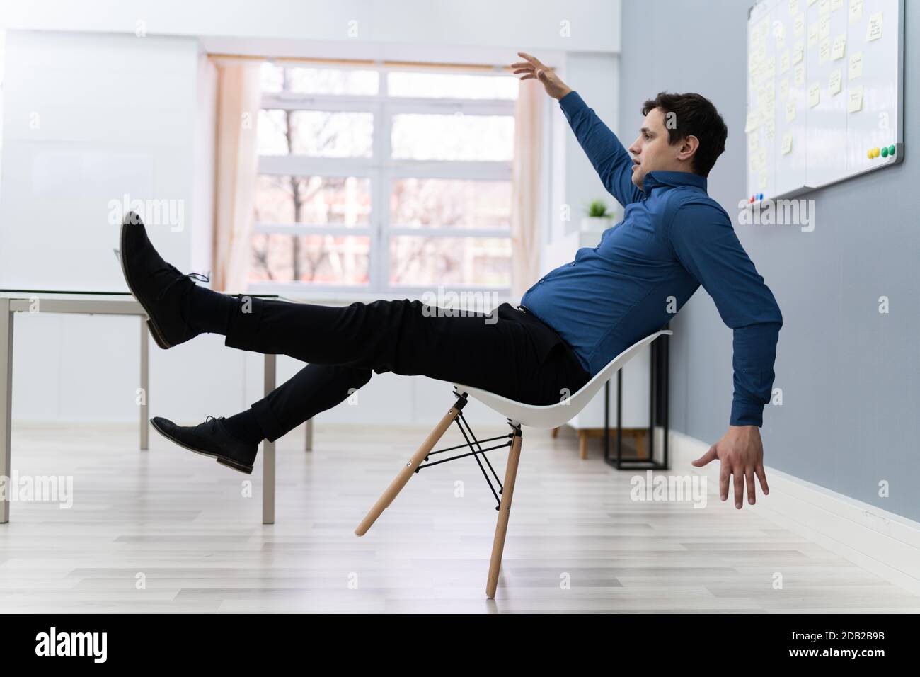 Photo Of Man Falling On Chair In Office Stock Photo Alamy