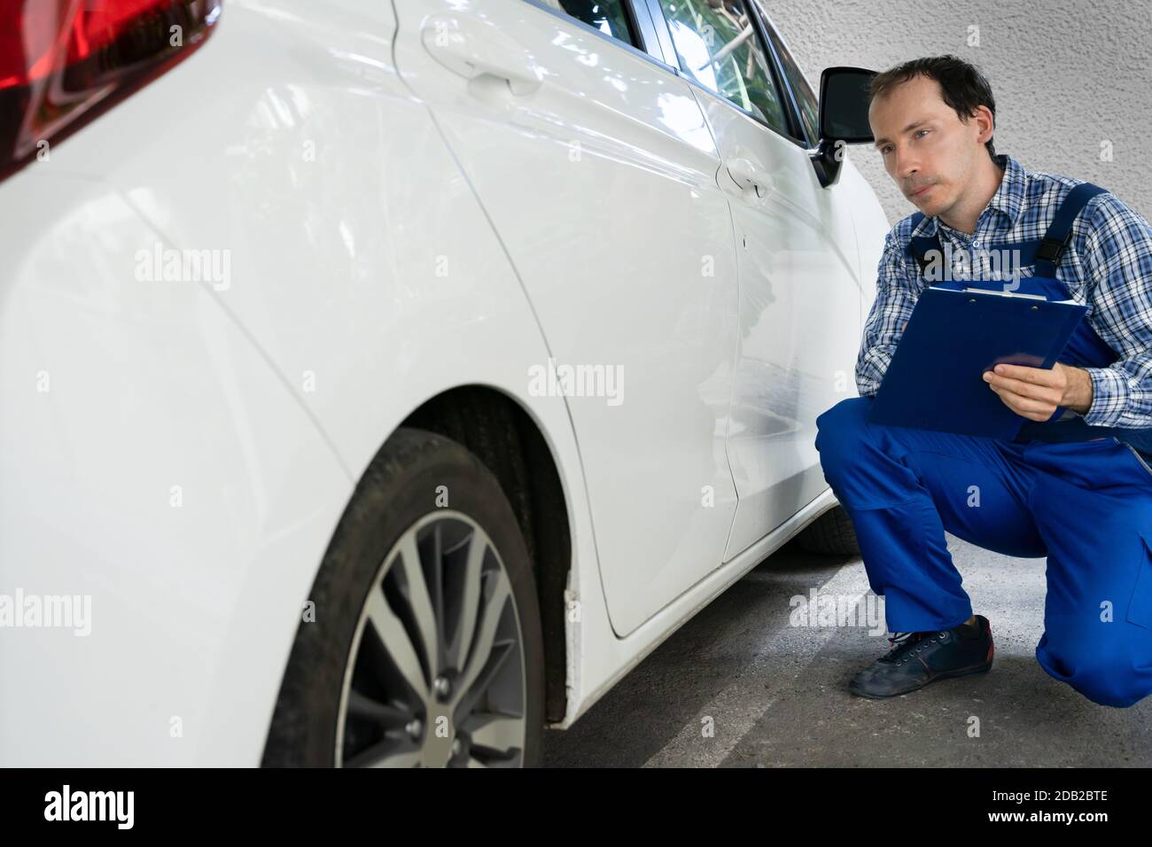 Insurance Agent Inspection White Car Paint For Scratches Stock Photo