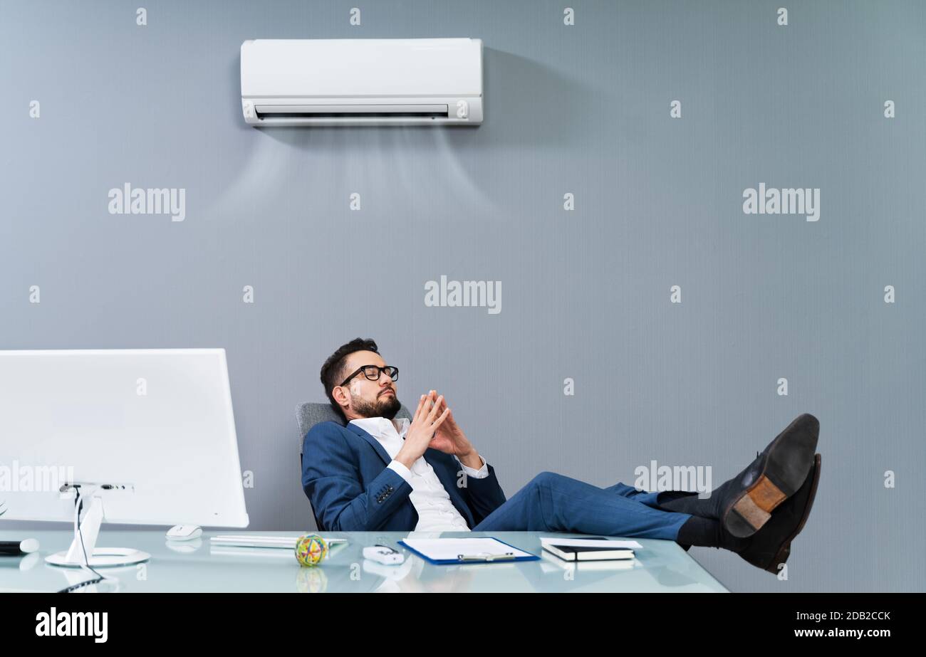 Relaxed Businessman Enjoying The Cooling Of Air Conditioner In The Office Stock Photo