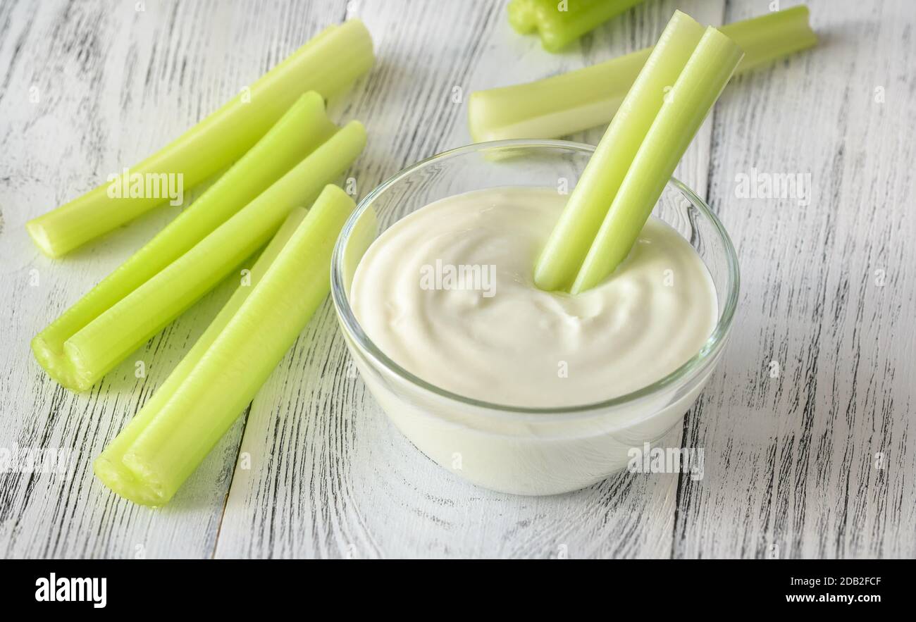 Leaf celery stalk dipped in Greek yogurt Stock Photo Alamy