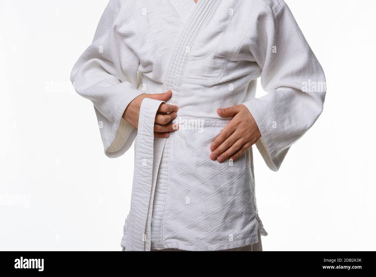 Stages of correct tying of the belt by a teenager on a sports kimono