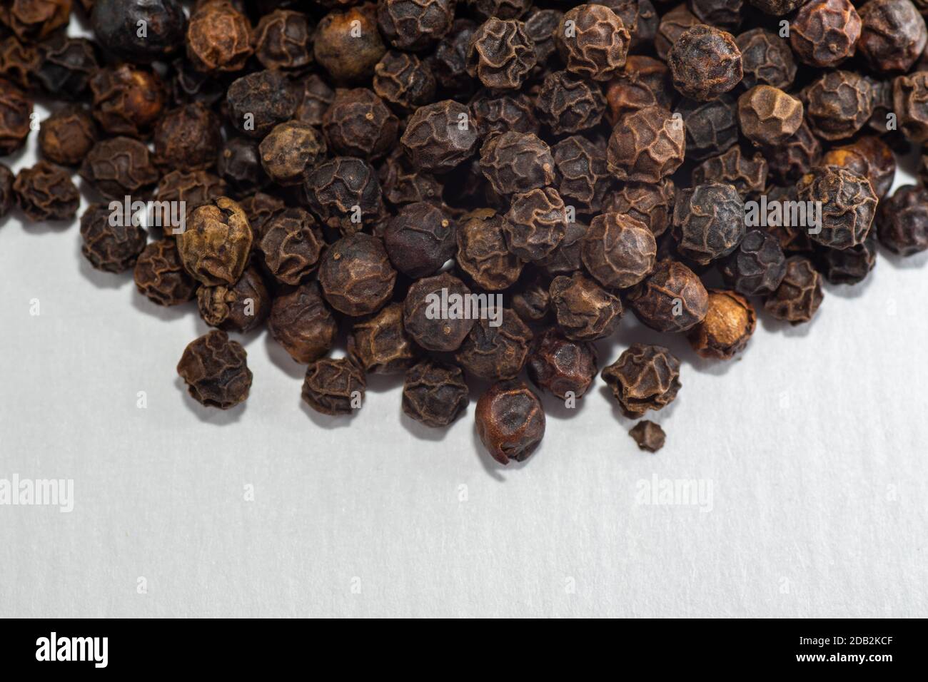 Close-up of a pile of black pepper isolated on a white background selective focus, copy space, macro. Stock Photo