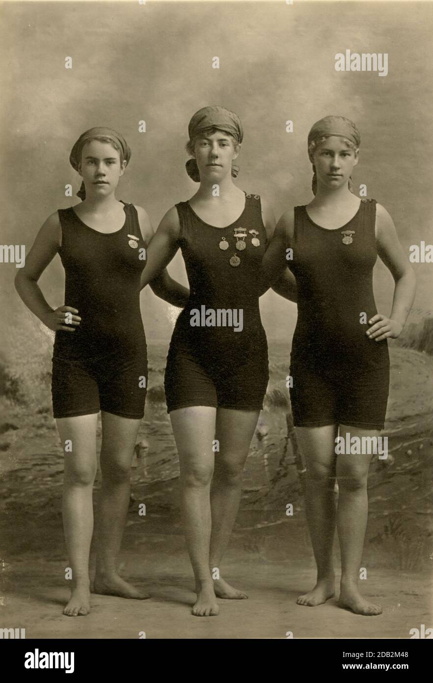 Three young women posing in swimsuits and wearing their swimming ...