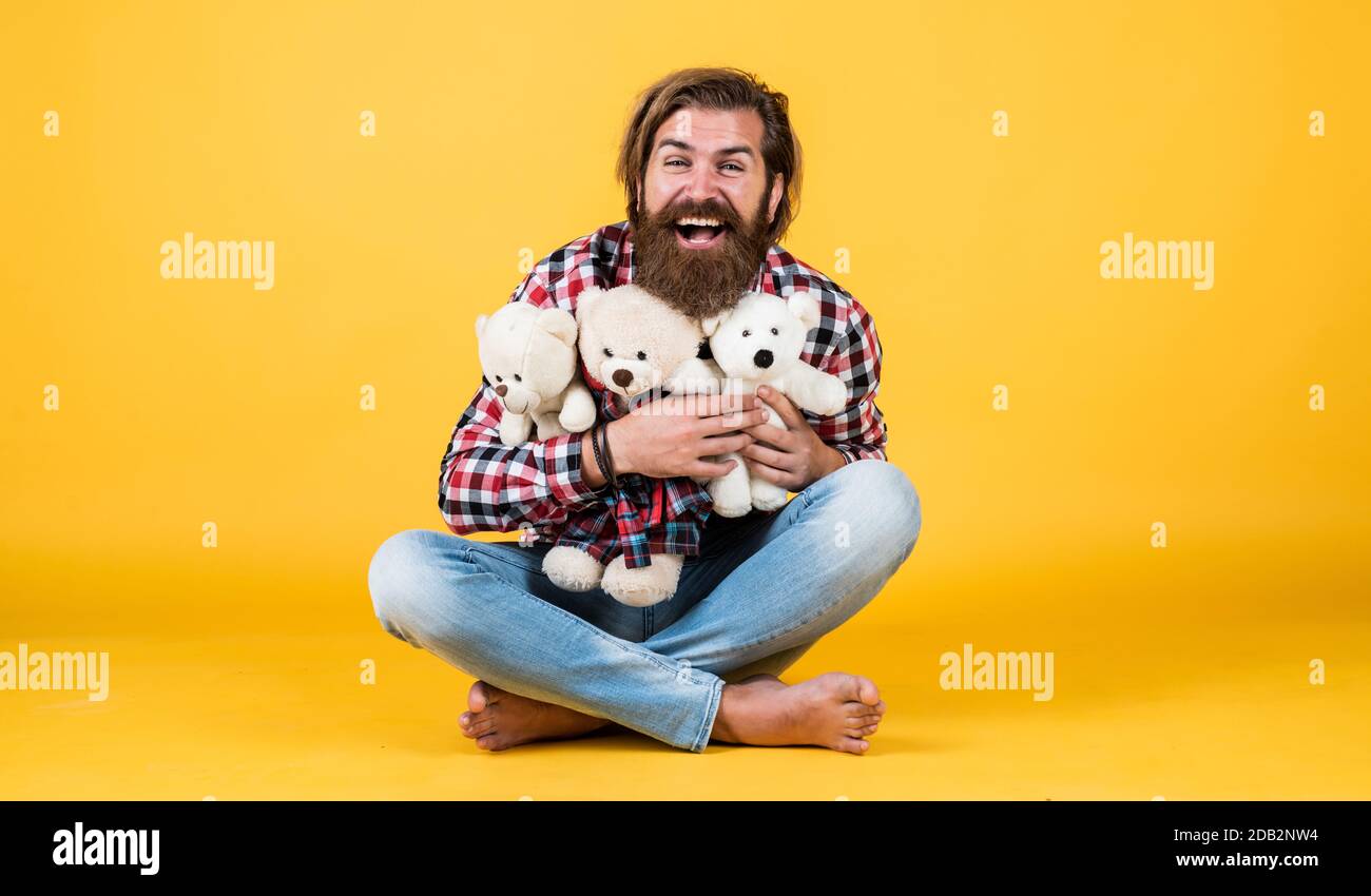 male feel playful with bear. brutal mature hipster man play with toy. happy birthday. being in good mood. happy valentines day. cheerful bearded man hold teddy bear. Love. Stock Photo