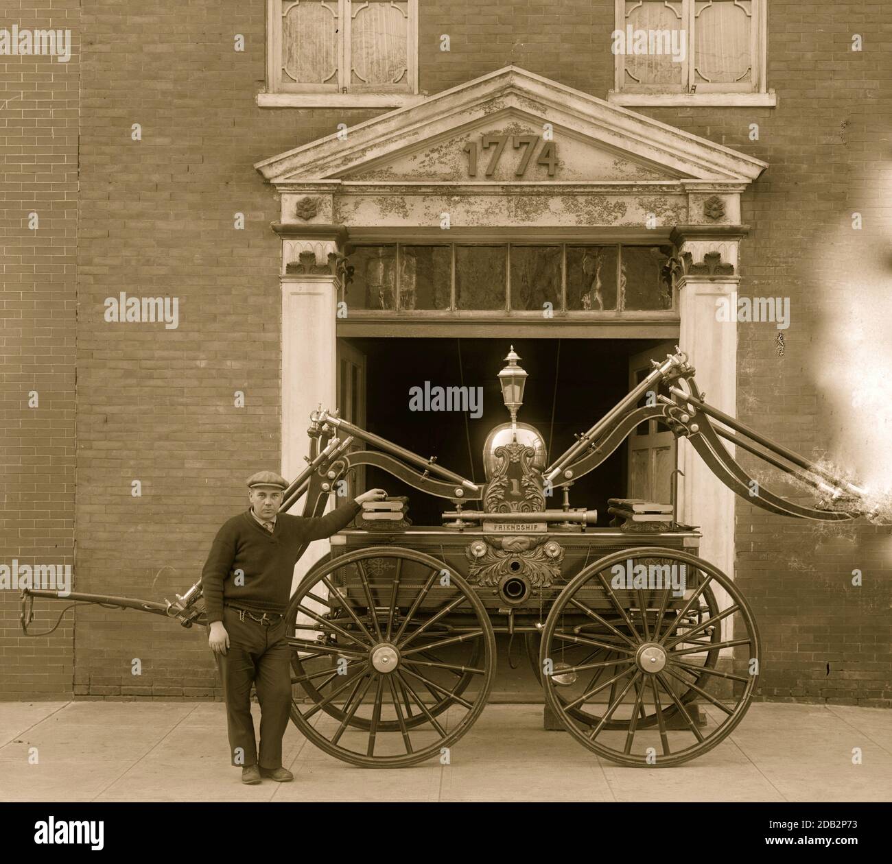 George Washington fire engine. Unusually interesting to visitors to Alexandria, Va., is this fire engine purchased by George Washington in 1775 at Philadelphia and regarded at the time as the most efficient type of engine. The engine is still in good condtion and reposes in the headquarters of the Friendship Fire Company in the old Virginia city where the Father of Our Country was an active member of the fire fighters in his day. G. William Humphries, present custodian of the fire house, is shown in the photograph, 3/6/31. Stock Photo