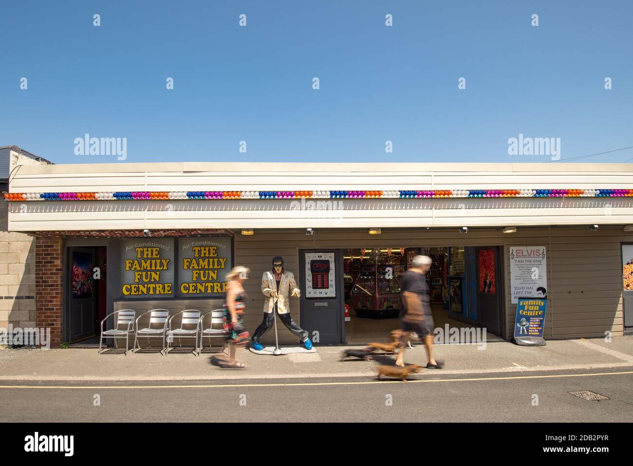 Amusement arcade with passers by in the small seaside village of Pagham in West Sussex, England, UK. Stock Photo