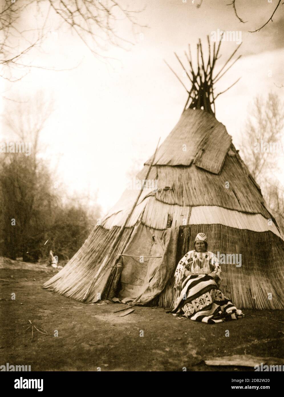 Edna Kash-kash, Yakima or Umatilla Indian, from Oregon, full-length portrait, seated in front of tepee, facing front. Stock Photo