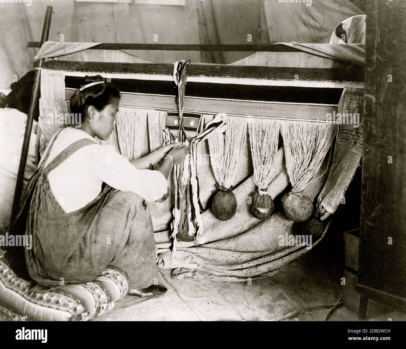 The pattern, a painted board, was designed by the men and represented clan or lineage crests. The weaving, by the women, was on a single bar loom; the materials used were cedar bark and goat wool. It took about one year to weave a single blanket. Source: The Handbook of North American Indians,. Stock Photo