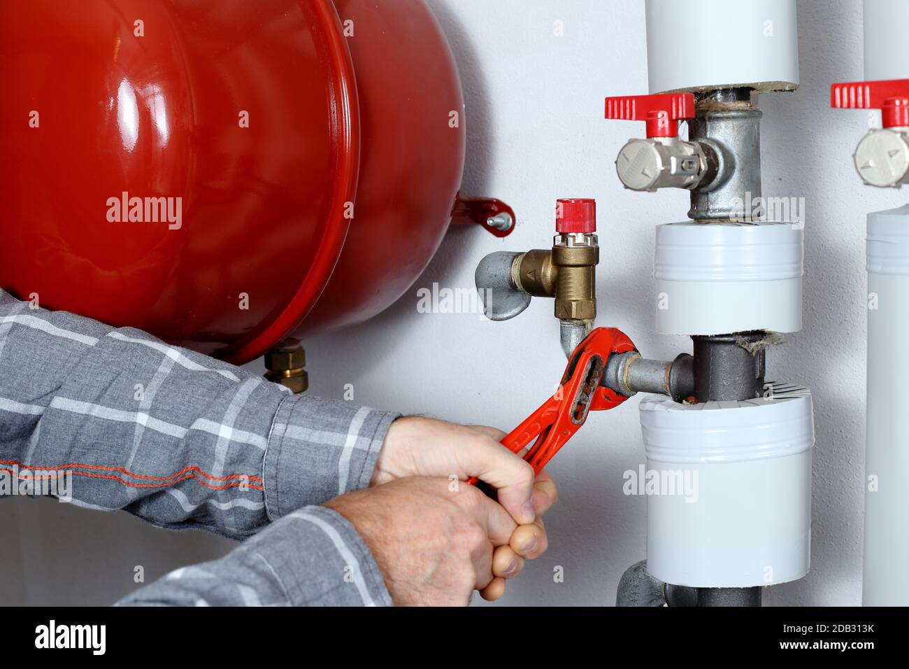 worker is fixing a metal pipe in a heating room Stock Photo
