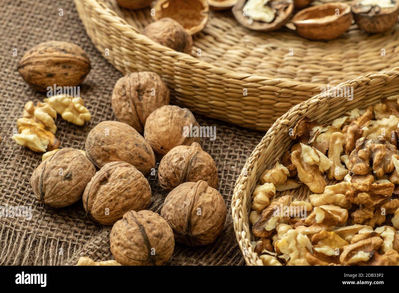 Walnuts on rustic natural burlap, Walnut kernels in wicker basket, Walnut background Stock Photo
