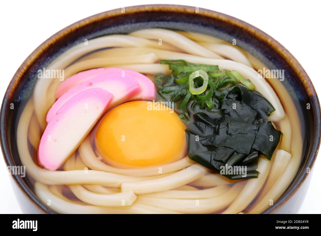 Japanese noodles in a ceramic bowl on white background Stock Photo