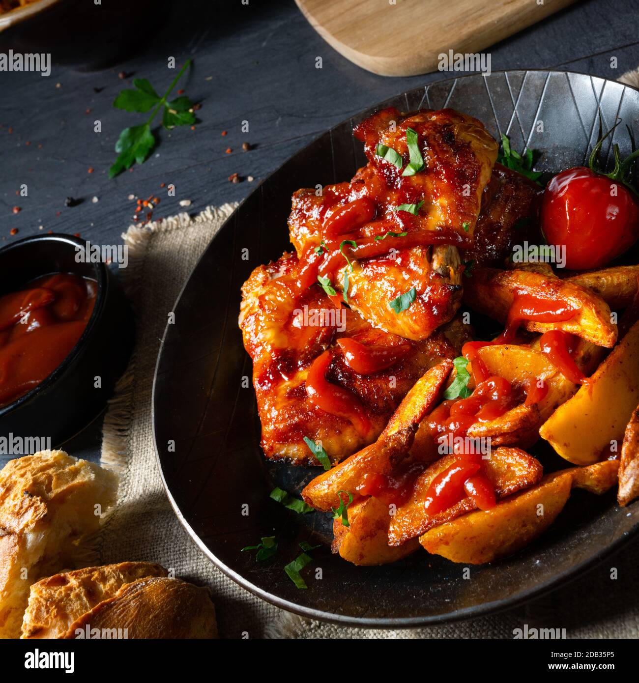 Rustic chicken wings in honey with potato wedges Stock Photo - Alamy