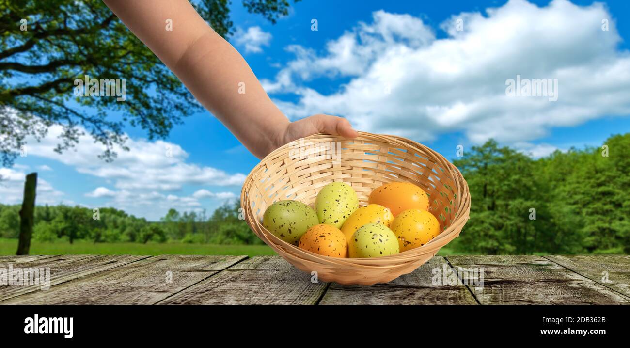 a hand holds an easter basket with easter eggs Stock Photo