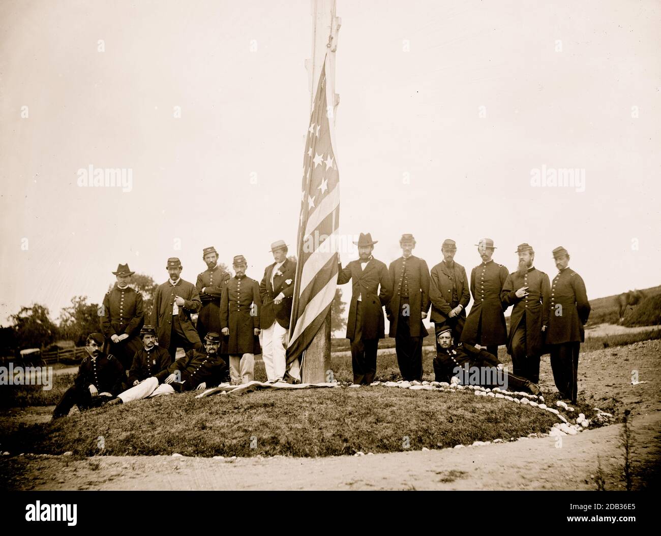 Washington, D.C. Signal Corps officers lowering flag at their camp near Georgetown; Gen Albert J. Myer, in civilian dress, at right of pole. Stock Photo