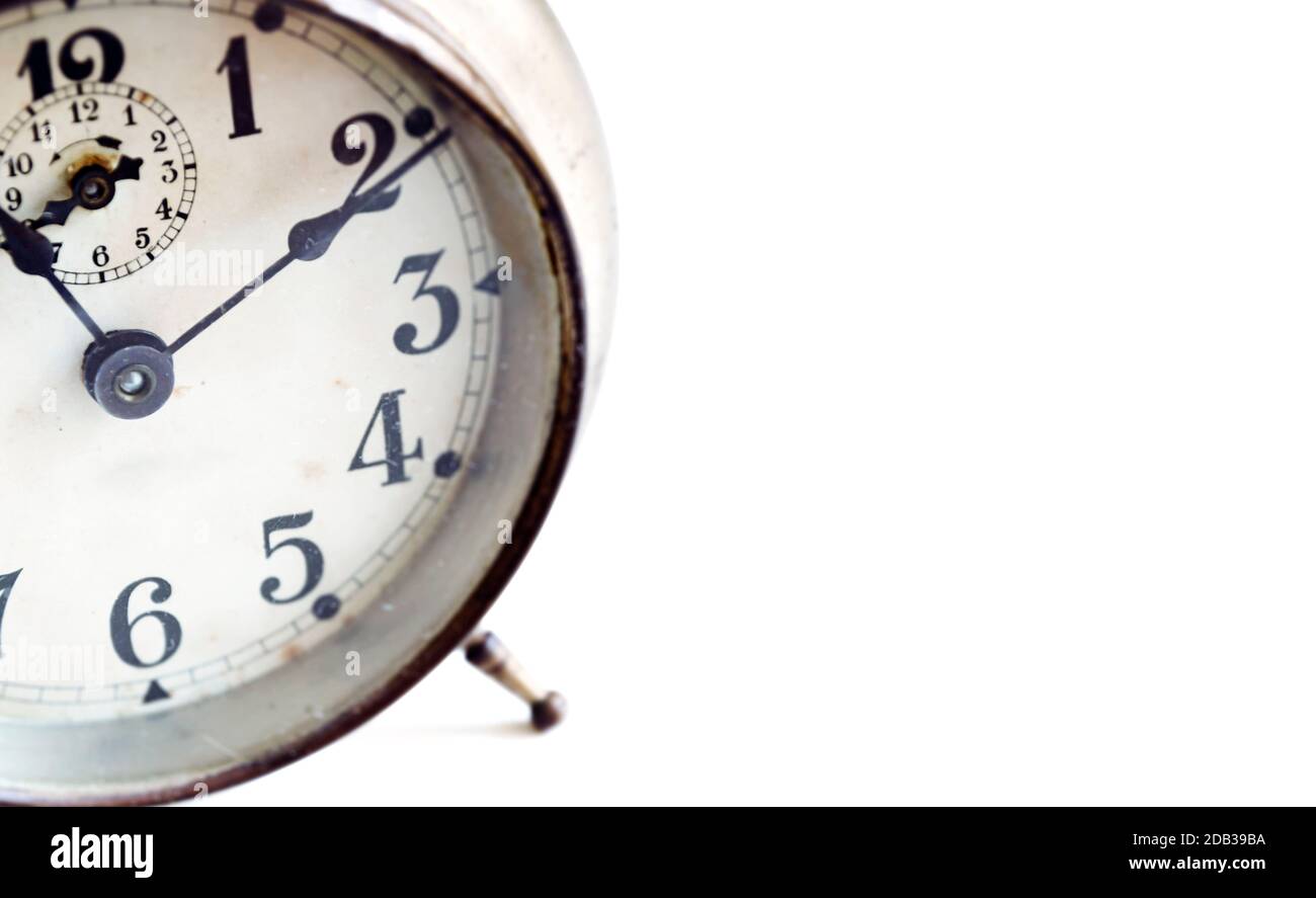detail of an old analog alarm clock isolated on a white background ...