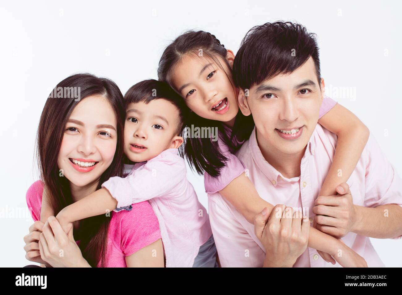 Young parents piggybacking their two kids isolated on white Stock Photo