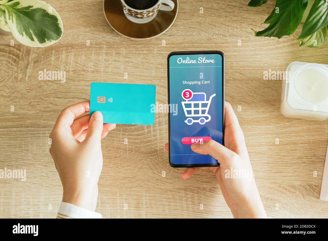 Mockup of a woman paying an order online with the phone and a credit card from home. E-commerce concept Stock Photo