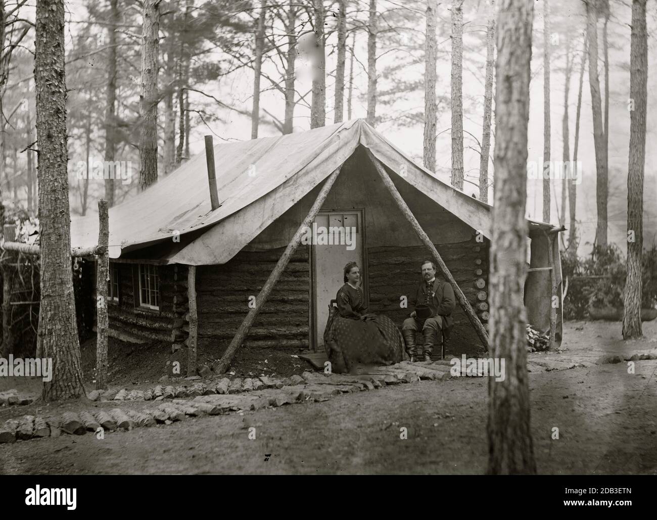 Brandy Station, Virginia. Col. John R. Coxe, A.C.S., and lady seated before his log-cabin winter quarters at Army of the Potomac headquarters. Stock Photo