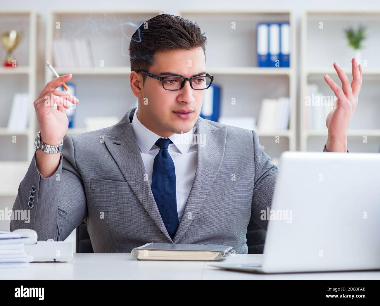 The businessman smoking in office at work Stock Photo - Alamy