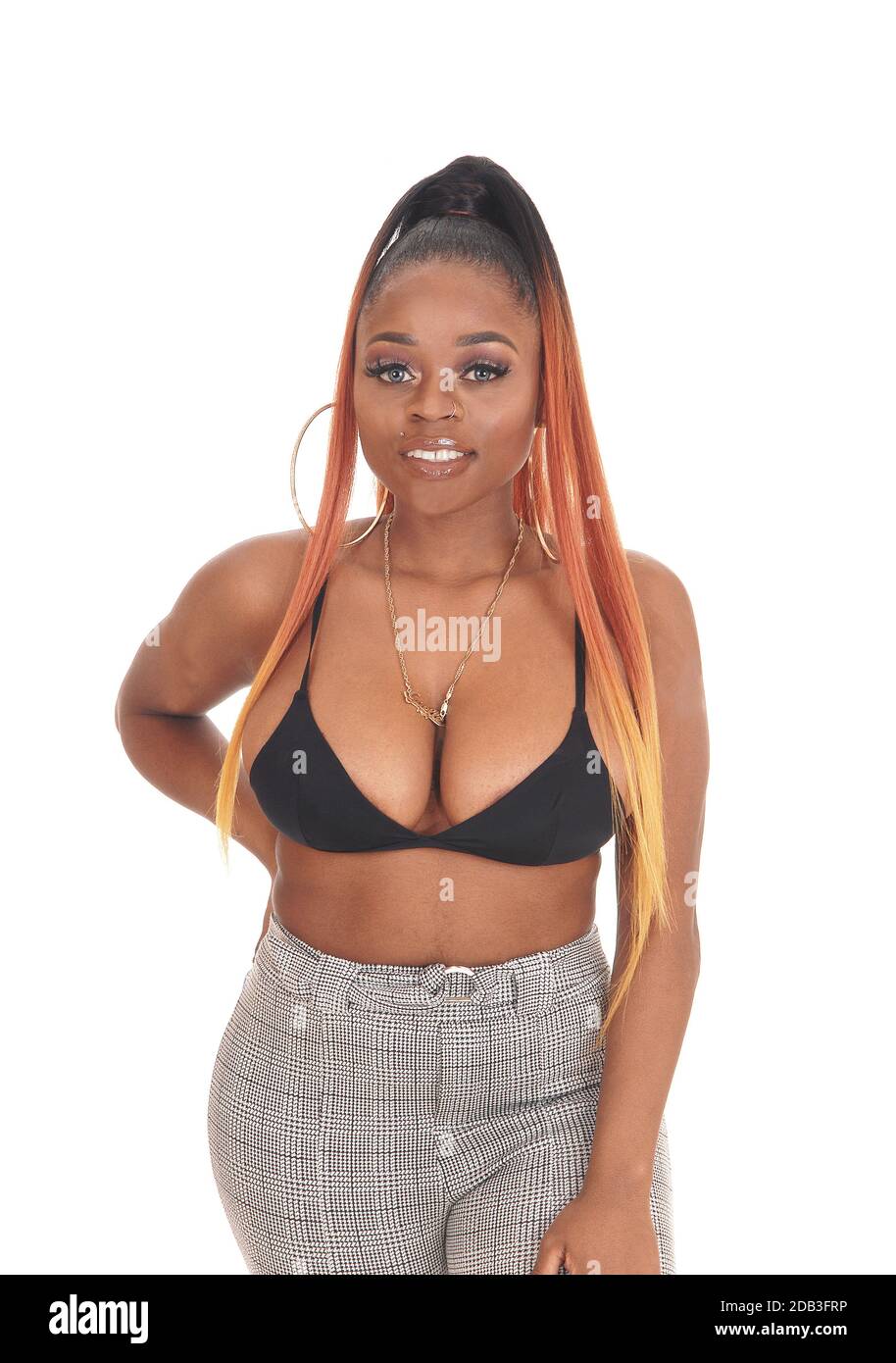 Gorgeous African American woman standing in the studio in gray pants and  black bra, with long hair, isolated for white background Stock Photo - Alamy