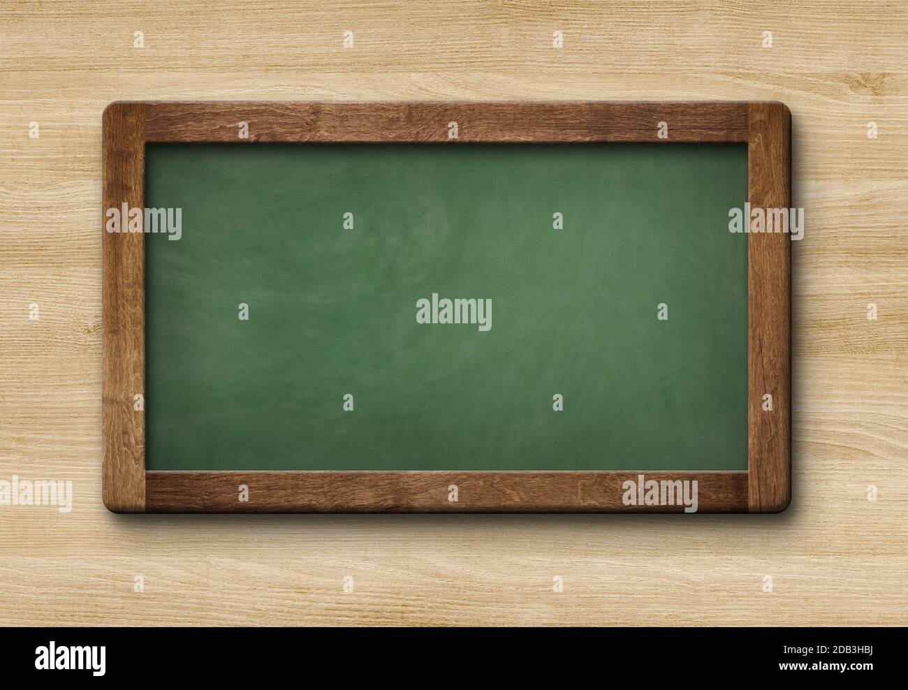Small blank green colored slate blackboard with wooden frame isolated on wooden background Stock Photo