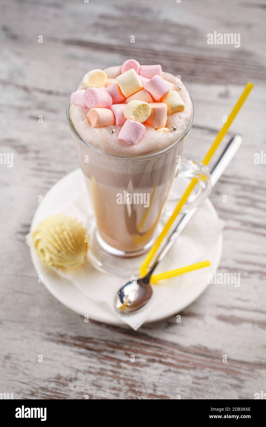 Milk cocktail with cream and marshmallow. Cocktail dessert on a simple ...
