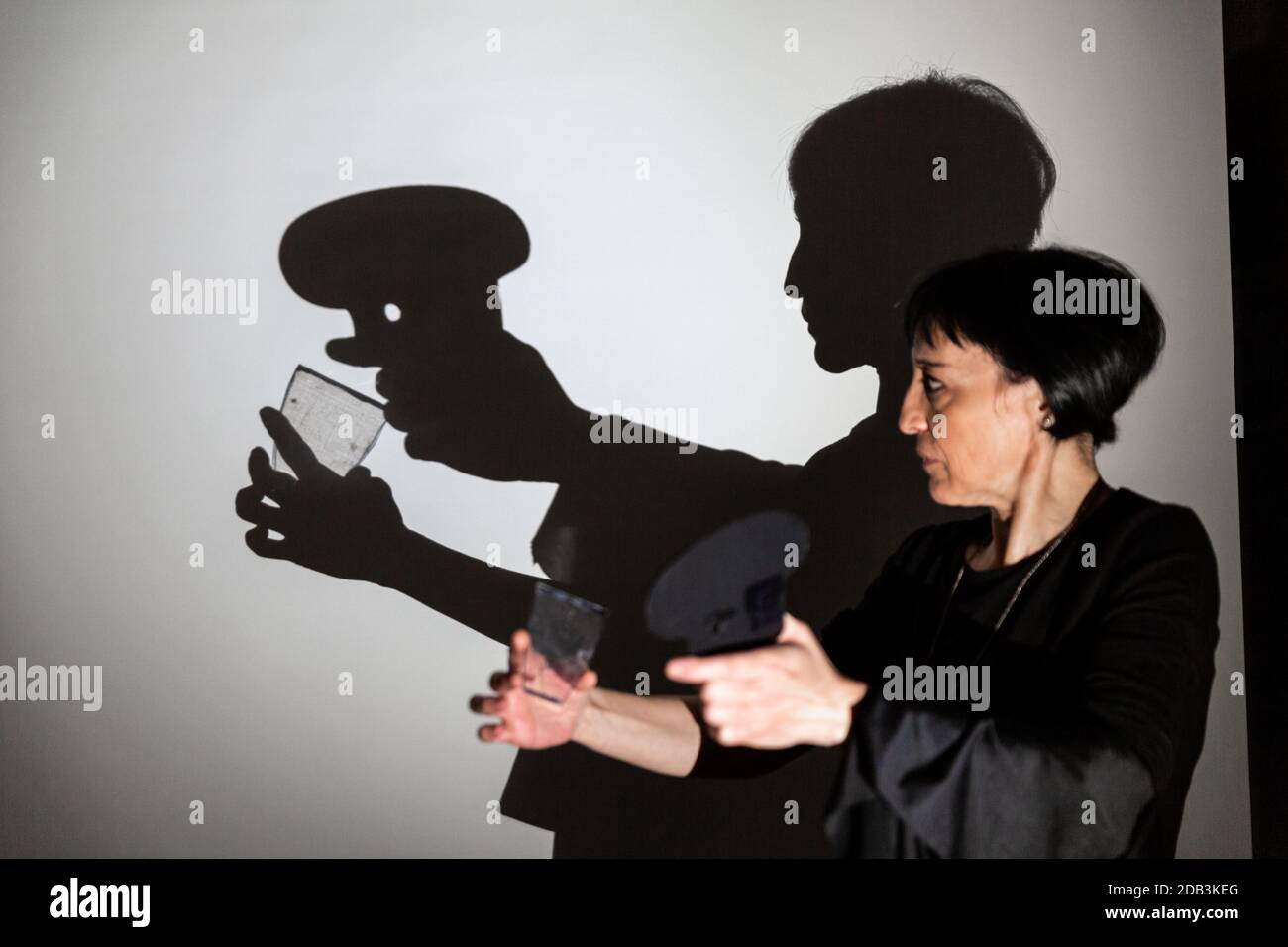 play shadow projected on a white screen. the person's hands shape a cook drinking from a glass Stock Photo