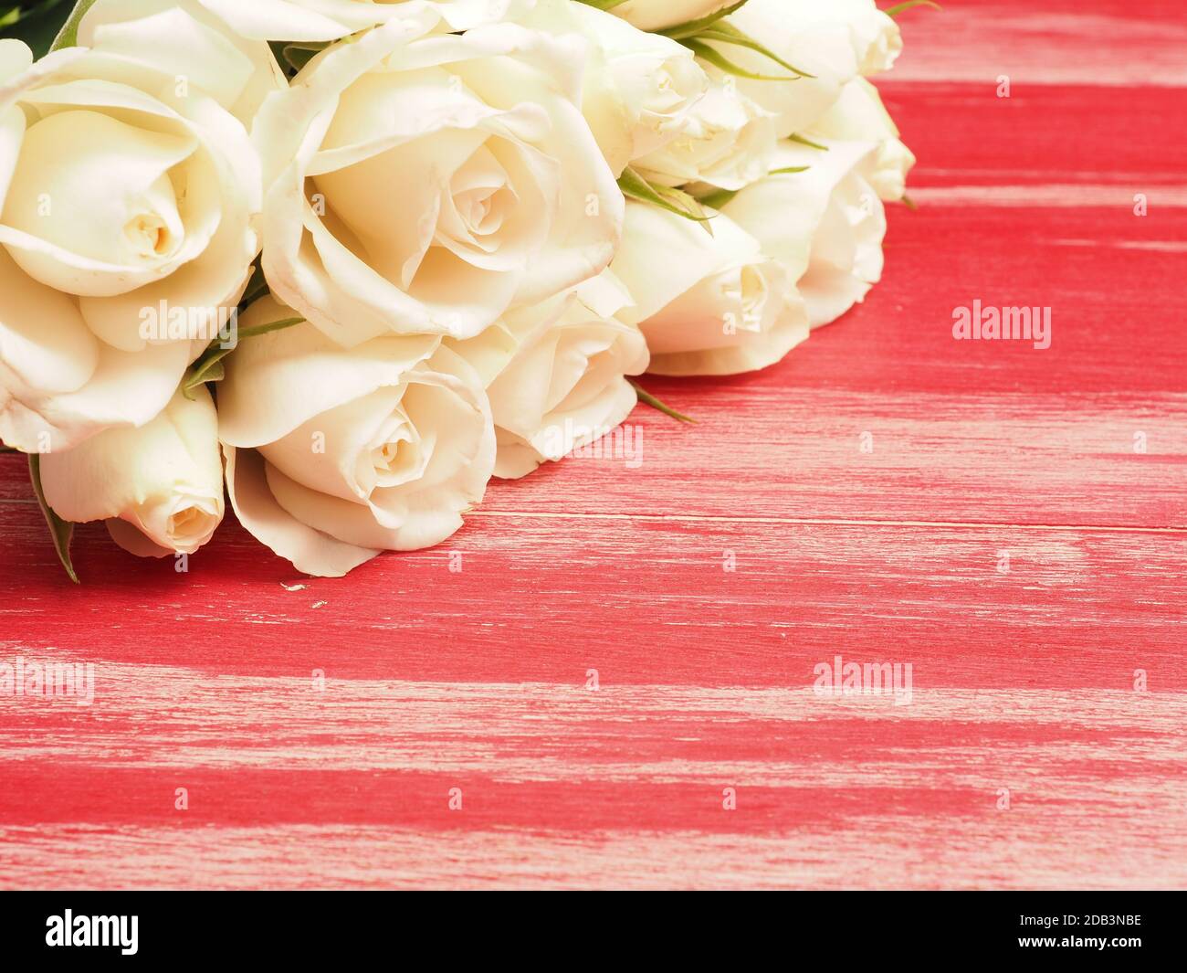 Bouquet of white roses on a red wooden table with space for your text ...