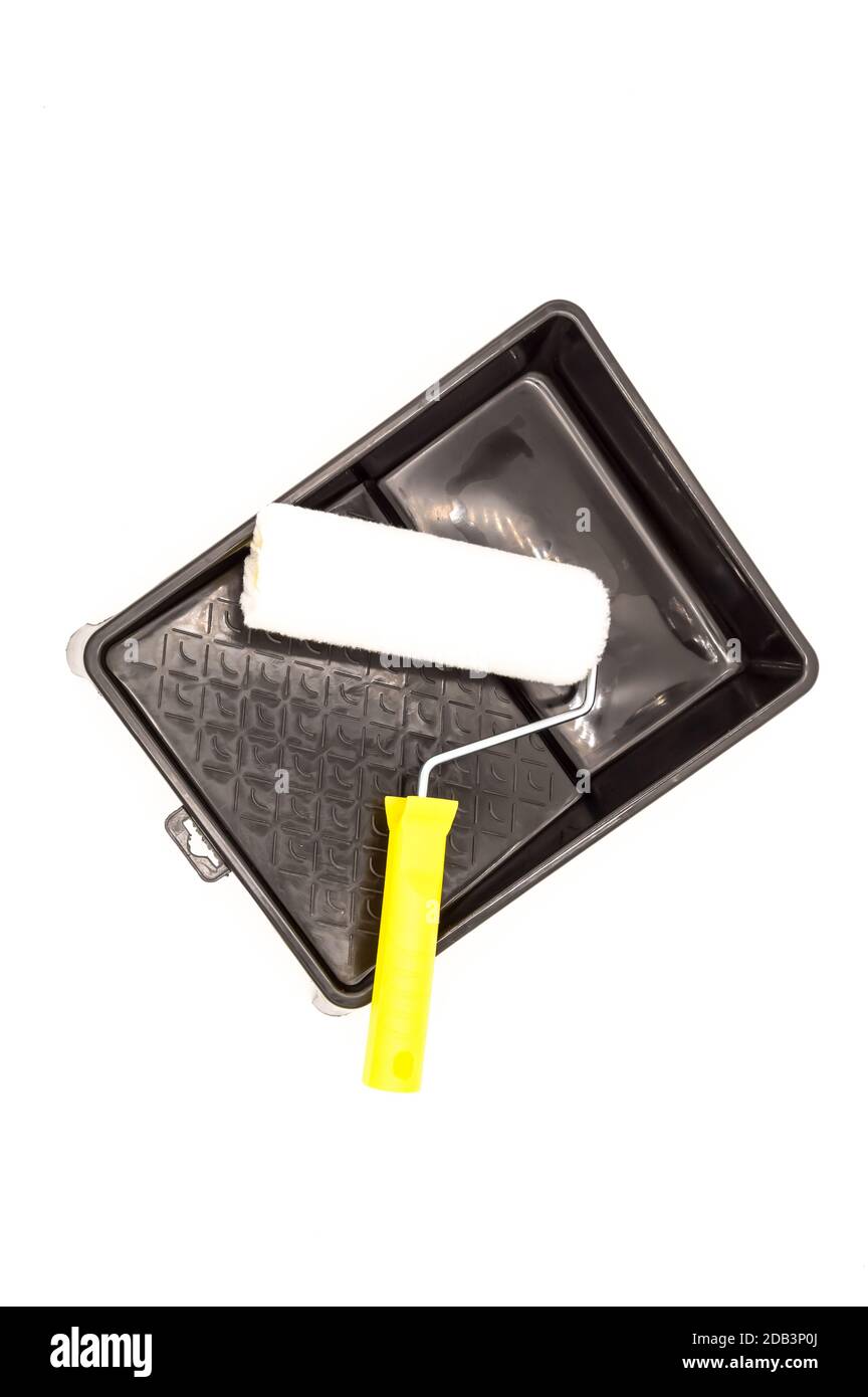 A clean paint roller rests on a black paint tray. Isolated on white