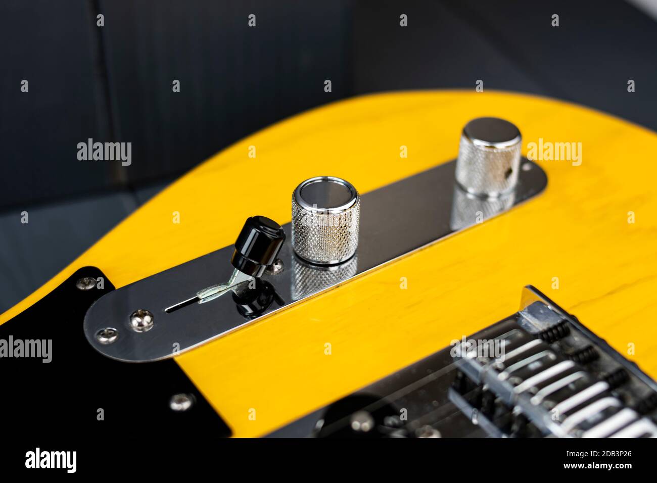 Closeup of the tone and volume controls, and pickup switch of a