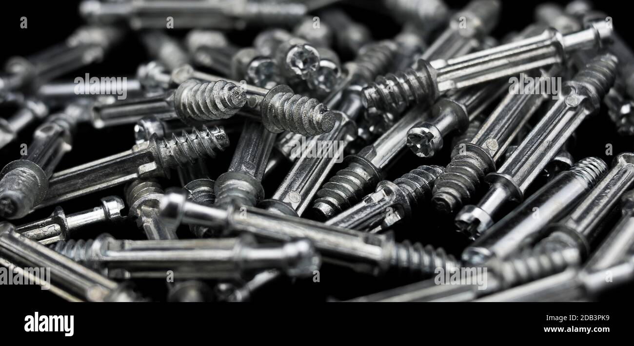 Pile of wooden furniture lock screws messily stacked on the table of a
