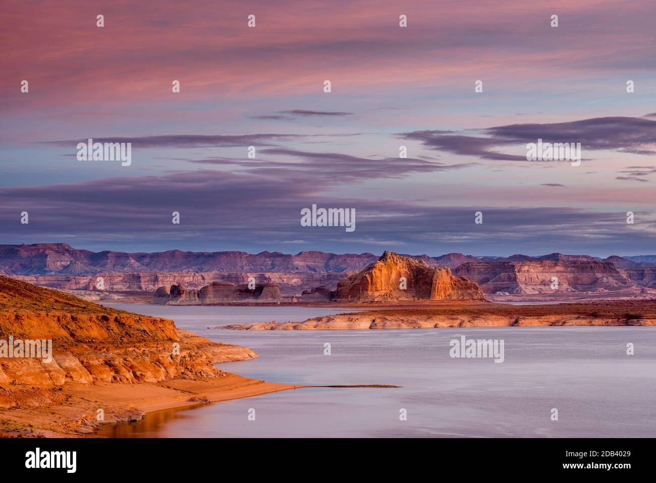 Unique scene of Lake Powell at sunrise with colorful clouds and rocky desert formations. Stock Photo