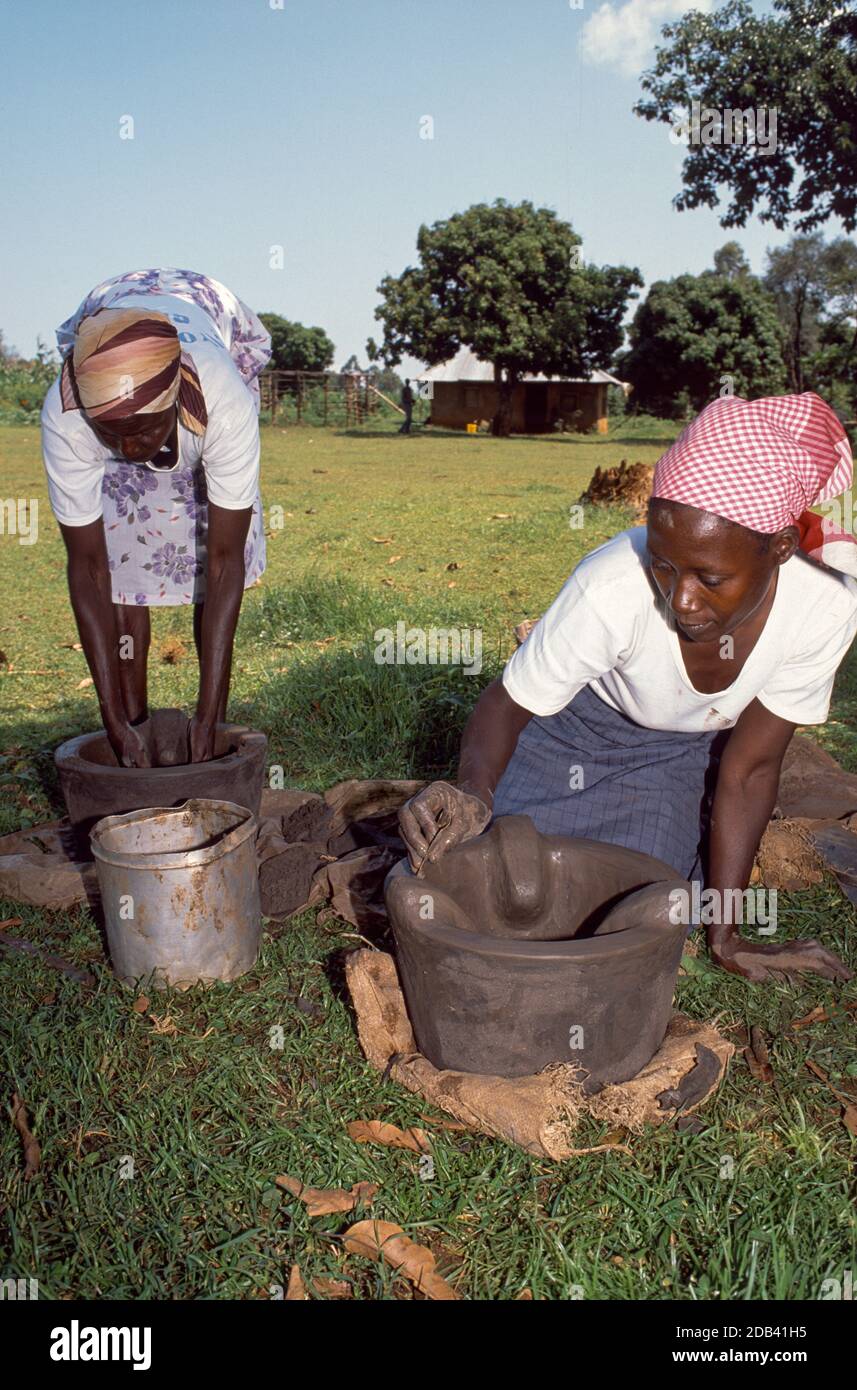 Two women from a women's cooperative making improved, efficient domestic clay stoves. Kisumu, Kenya Stock Photo