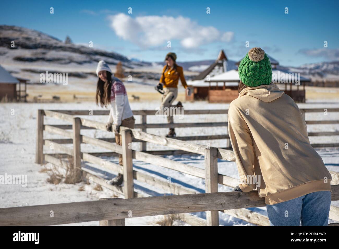 Three young girls friends are having fun at first snow in mountains. Winter vacations concept Stock Photo