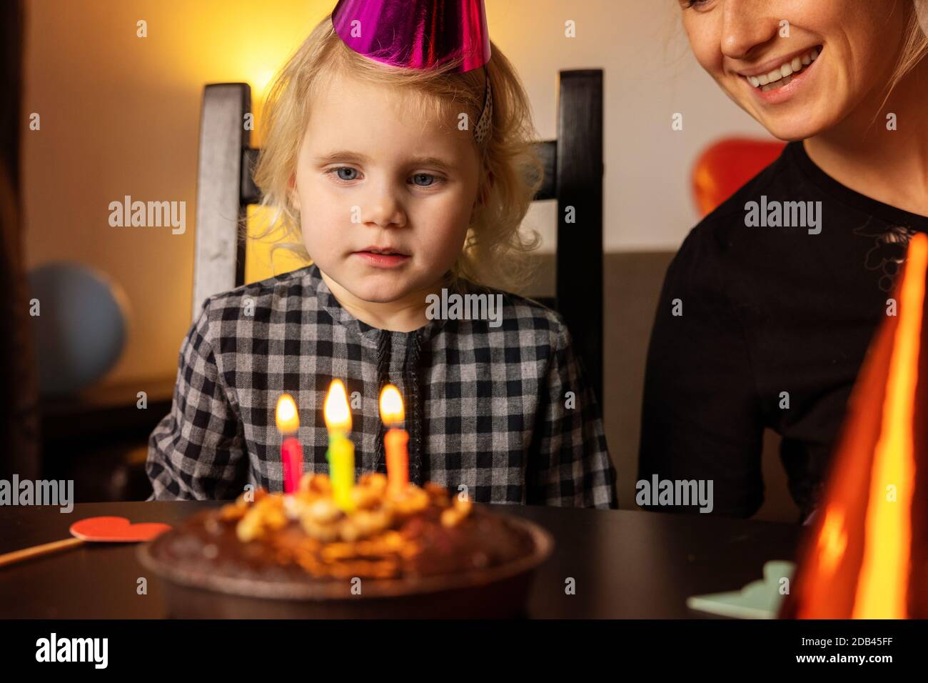 little girl make a wish before blow out the candles on her birthday