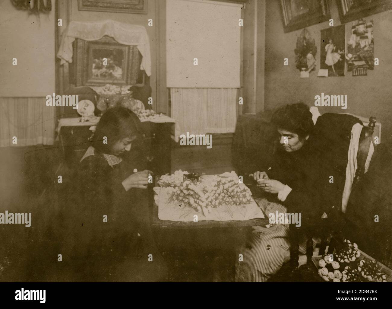 Flower making. A night scene (Photo at 10:30 P.M. and not finished, Jan 29, 1912). Carrie Brindisi,12 years old, 134 1/2 Thompson Street, 2[nd] floor] front. Carries [sic] goes to school. Works after school and nights, Rosie (six years old) helps too.. Stock Photo