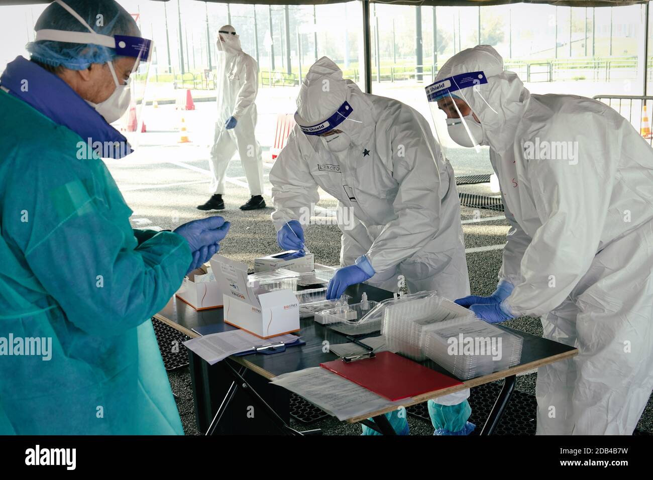 Medical worker in PPE performing nasal & throat swab on person in vehicle through car window,COVID-19 mobile testing centre. Turin, Italy - November 2 Stock Photo