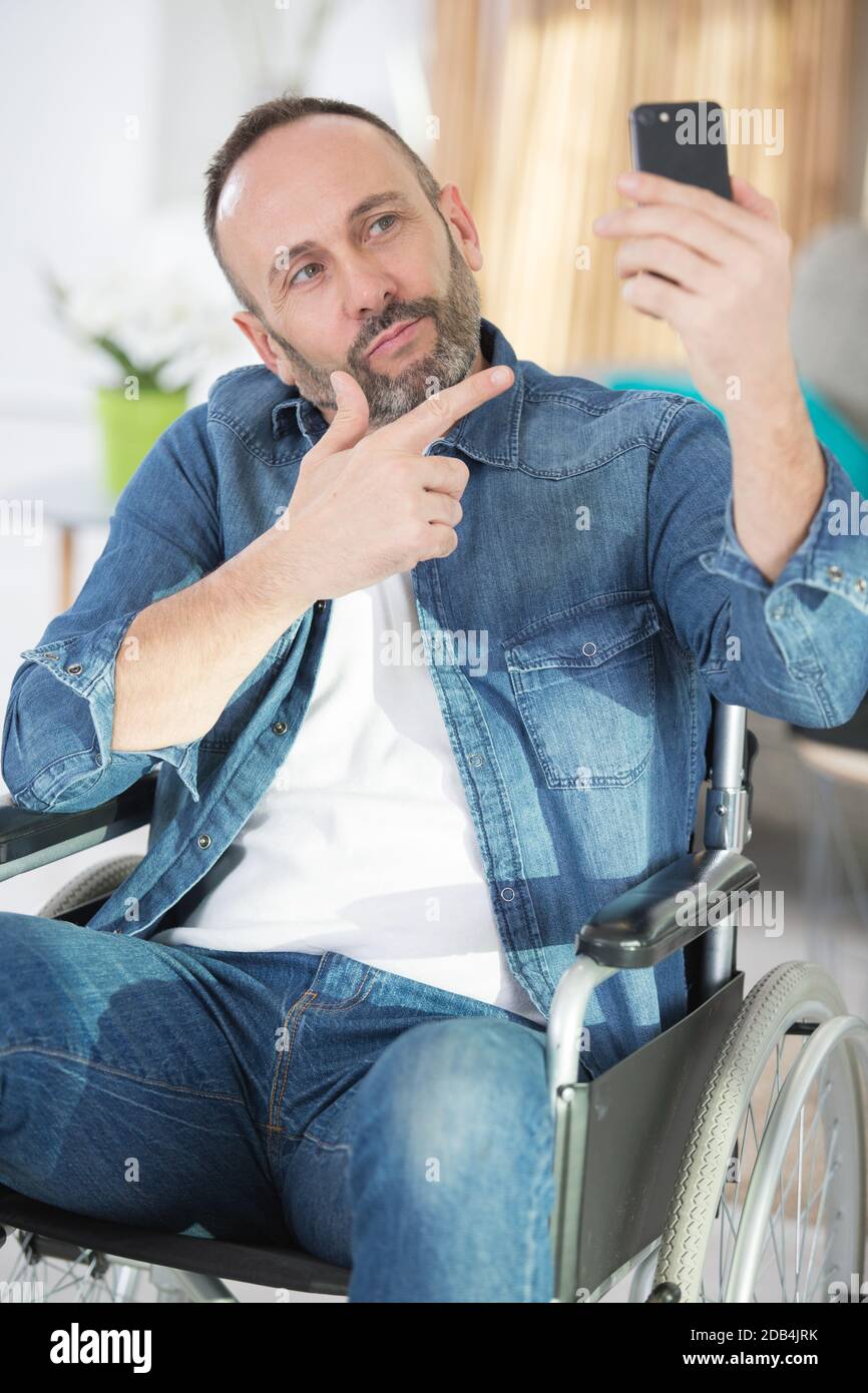 disabled man in a wheelchair posing for a selfie Stock Photo - Alamy