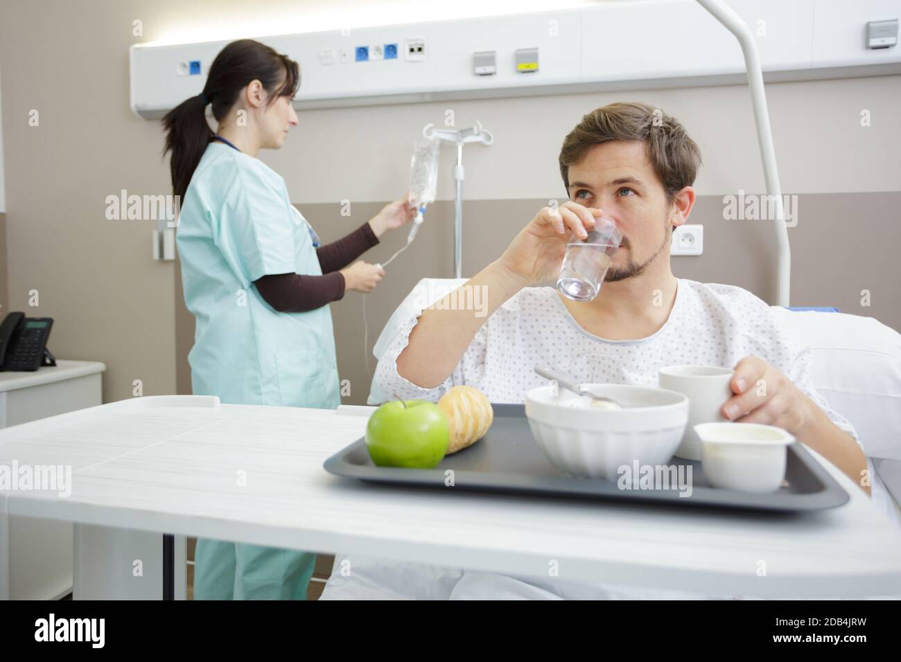 patient in hospital bed eating food from tray Stock Photo Alamy