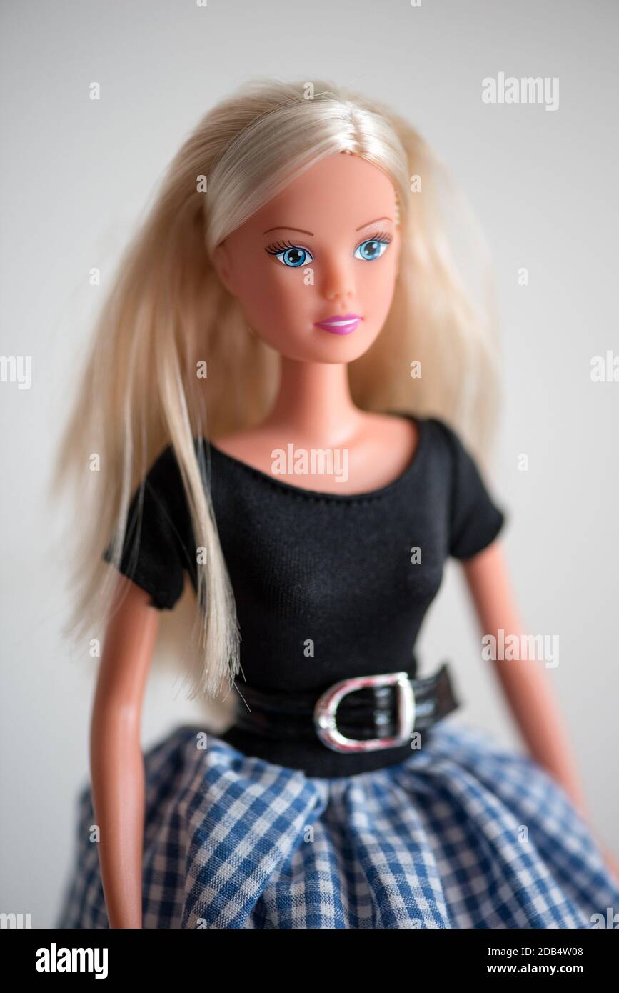 Single smiling blue eyed doll in black blouse, long blond hair and