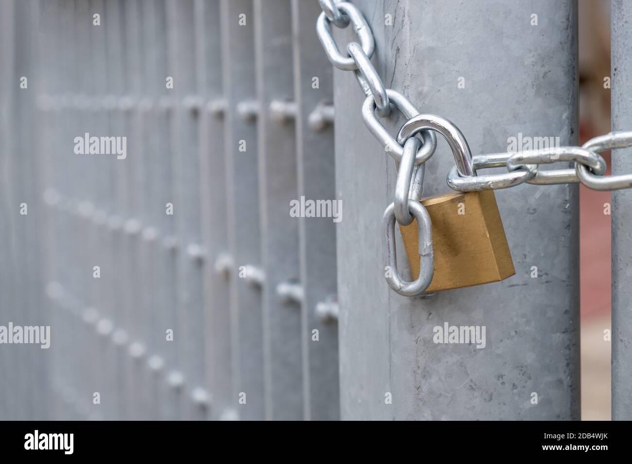 Heavy metal padlock with chain closeup on an entrance gate. Safety, security concept Stock Photo