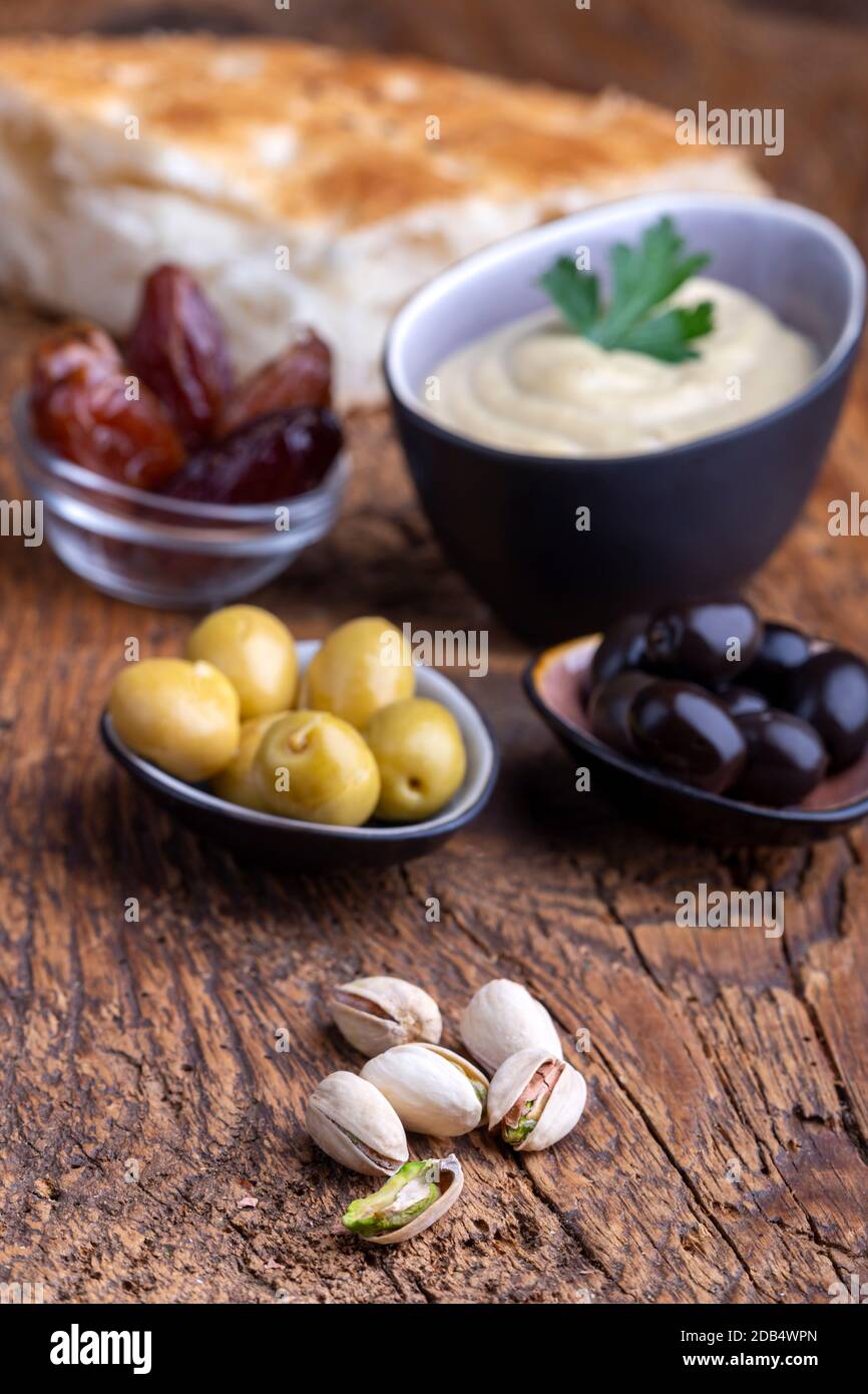 olives and hummus on dark wood Stock Photo