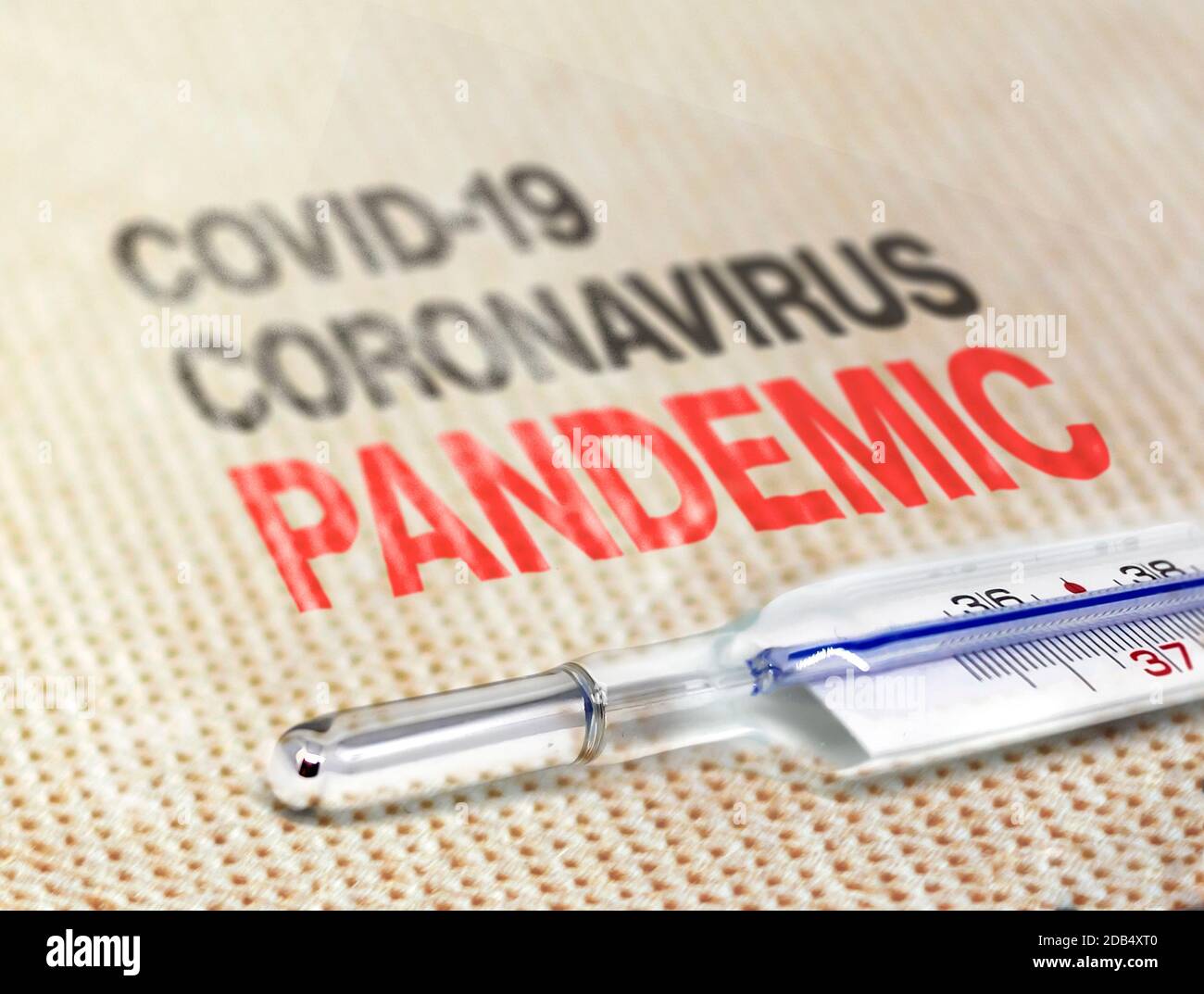 a thermometer resting on a soft surface indicating the Covid-19 Coronavirus pandemic. Worldwide Virus pandemic Stock Photo