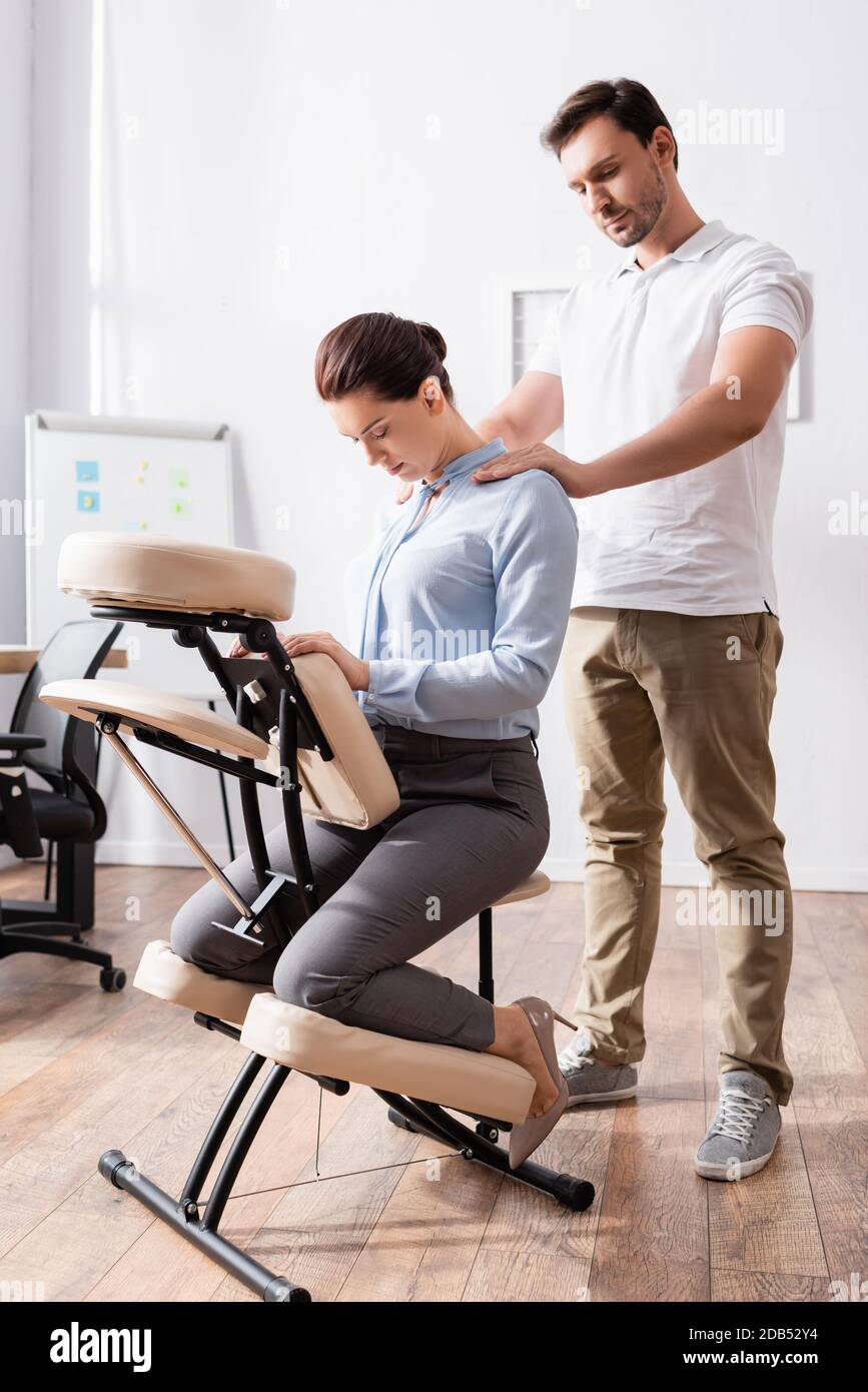 The masseur makes a relaxing massage of the trapezius muscles and back to  the client lying on the couch Stock Photo - Alamy